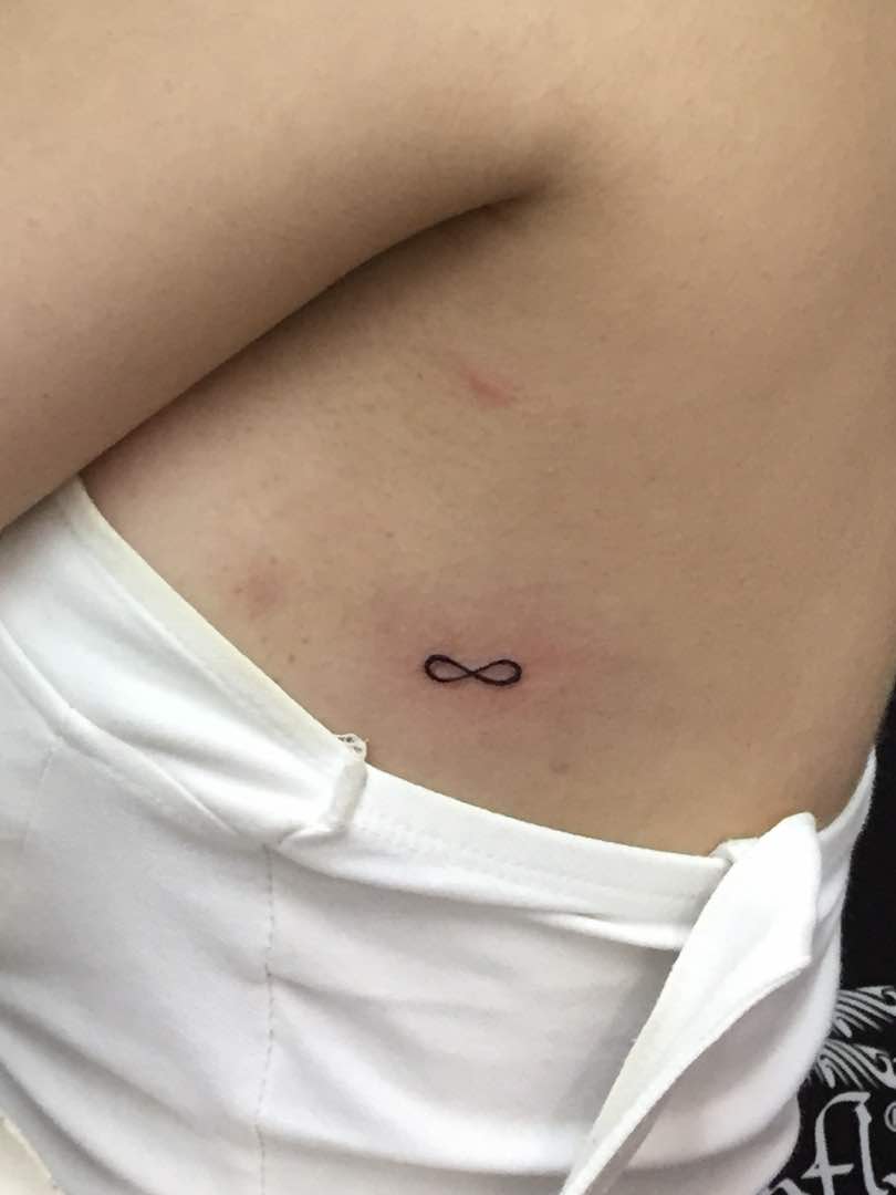 Infinity sign with name, tattooed on the hip